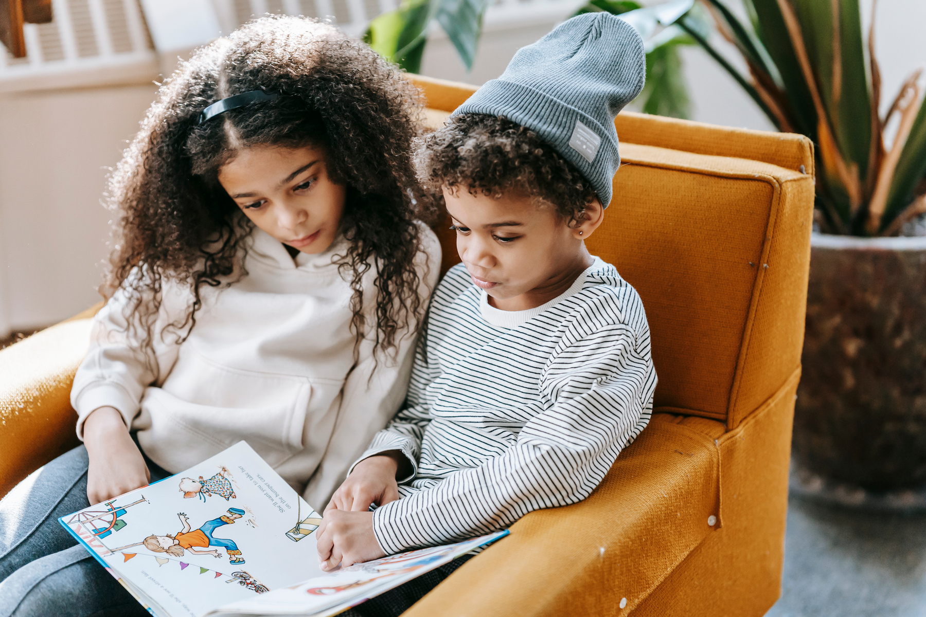 Serious black kids reading interesting book together